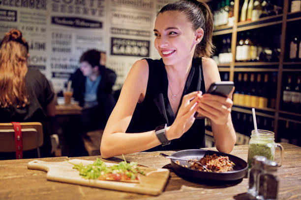 istock Young woman is eating and texting in a restaurant 1283758477