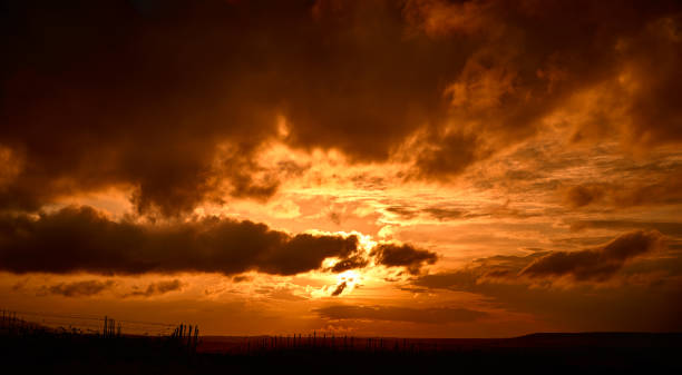 istock Panorama of dark dramatic orange clouds in evening sky 1283758734