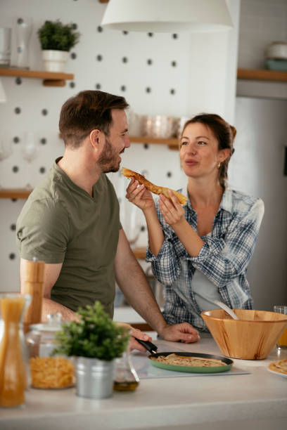 istock Husband and wife making pancakes at home. 1283760086