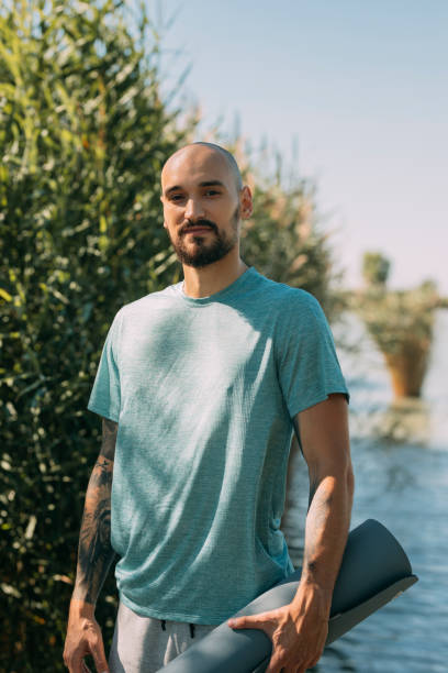 istock Portrait of a Yogi: Handsome Tattooed Man Ready to Exercise by the Lake 1283760796