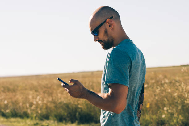 istock Outdoor Workouts: a Runner Checking his Phone before Going for a Run in the Countryside (Copy Space) 1283760875