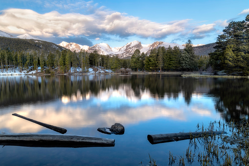Hallett Peak and the Continental Divide reflect in the waters of Sprague Lake located in Rocky Mountain National Park