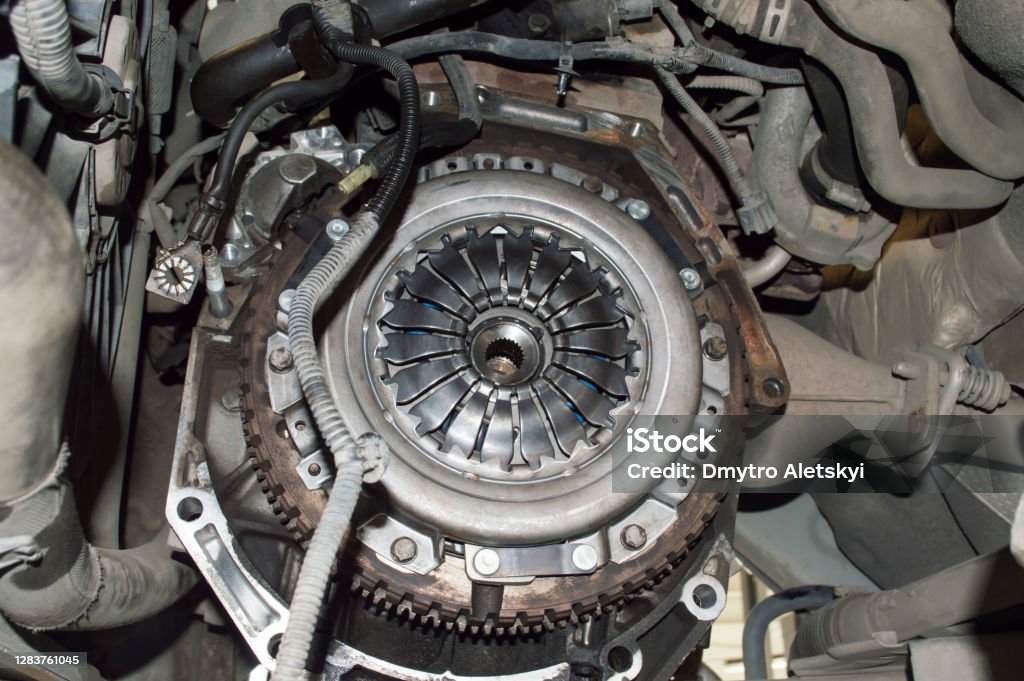 View of the clutch basket mounted on the car View of the engine compartment of the car from the side of the removed manual transmission. The clutch basket and the gear ring of the flywheel are visible Vehicle Clutch Stock Photo