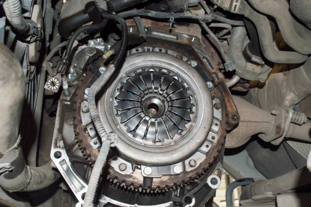 View of the clutch basket mounted on the car View of the engine compartment of the car from the side of the removed manual transmission. The clutch basket and the gear ring of the flywheel are visible dismantling photos stock pictures, royalty-free photos & images