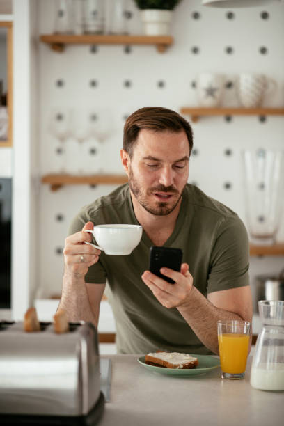istock Young man eating breakfast and reading the news online. 1283761178