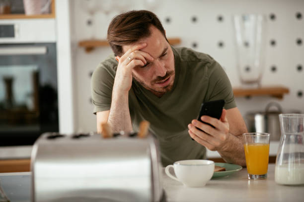 istock Young man eating breakfast and reading the news online. 1283761287
