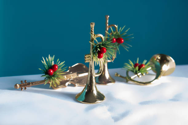 The two trumpets horn and violin festively decorated with a blue and white background. Christmas still life for musicians.