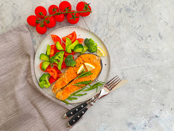 istock fried salmon slice on a plate, tomato on concrete background 1283761529