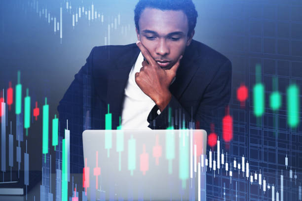 istock Serious young African businessman with laptop, graphs 1283766325
