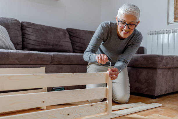 istock Mature woman installing bookcase. 1283769398
