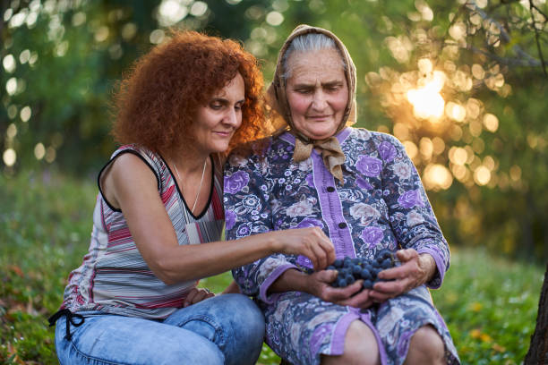 istock Mother and daughter eating grapes at sunset 1283772723