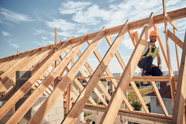 istock Careful contractor working with a hammer high on the building 1283773610