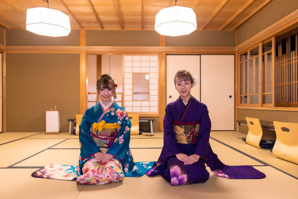 young women in ‘furisode’ kimono sitting on heels in japanese ‘tatami’ room in ‘ryokan’ hotel - camel fair imagens e fotografias de stock