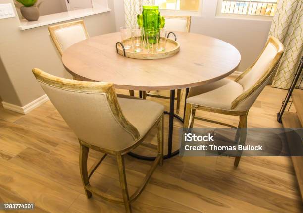 Dining Area With Round Wooden Table Four Chairs Stock Photo - Download Image Now - Baseboard, Bookshelf, Centerpiece