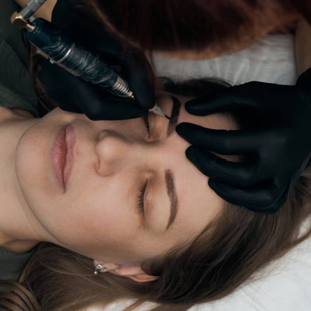 istock Permanent eyebrow makeup procedure. Eyebrow tattooing, process. The use of tools by a master for permanent eyebrow makeup. 1283776529