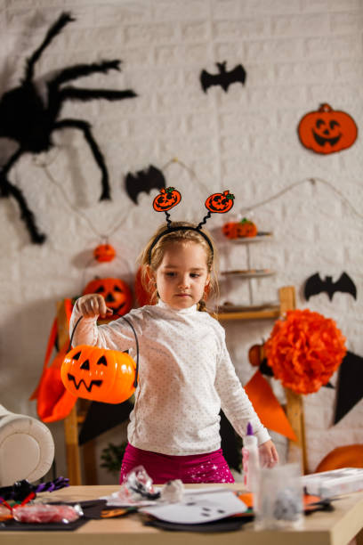 istock Getting her Jack o' lantern bucket for trick or treating 1283776693