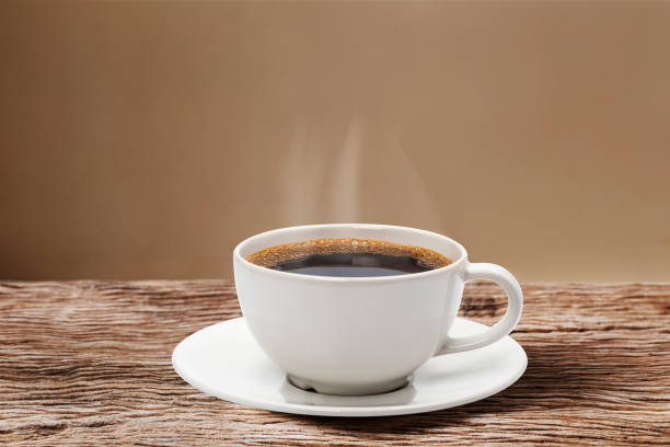 corazón de vapor flotando sobre una taza de café rojo sobre mesa de madera con fondo de pared crema. - coffee cup coffee cup bubble fotografías e imágenes de stock