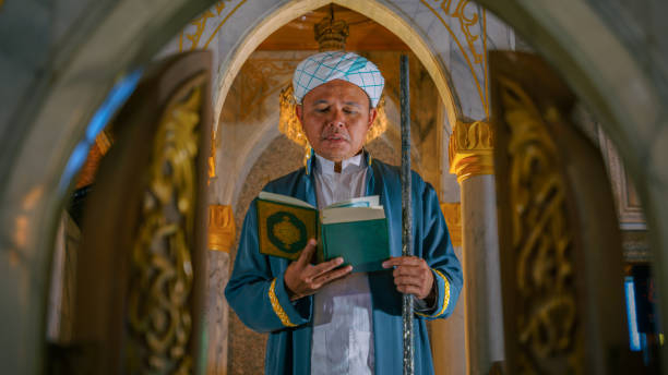 islam imam with koran book on hand making speech in isramic worship ceremony in mosque stock photo