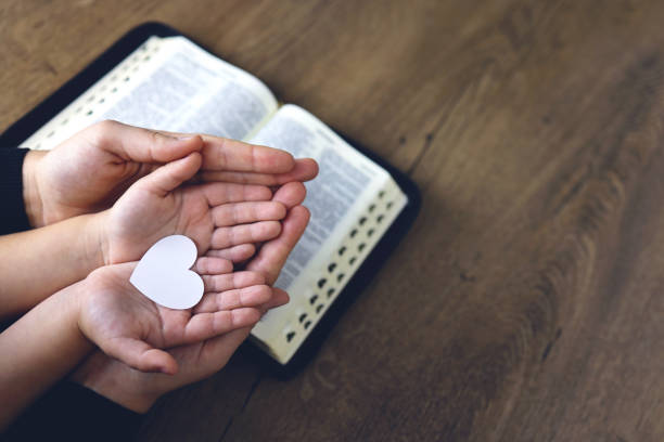 chica cristiana religiosa rezando con su madre en el interior - no culpable fotografías e imágenes de stock