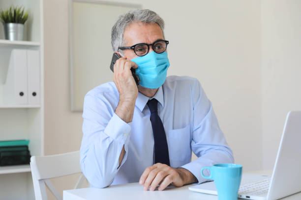 istock Coronavirus man wearing face mask using antiseptic bottle dispenser hand sanitizer alcohol gel hand wash to sanitize hygiene prevent corona virus health infection antibacterial during covid19 pandemic 1283783605