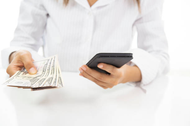 istock mobile phone with hand holding dollars 1283787465