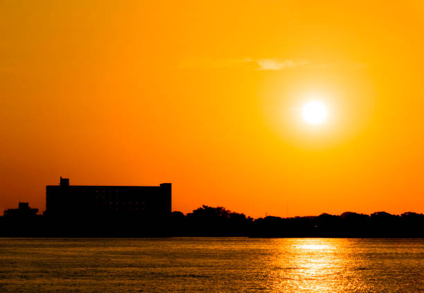 Landscape of building with orange sunset sky reflection on water in the river