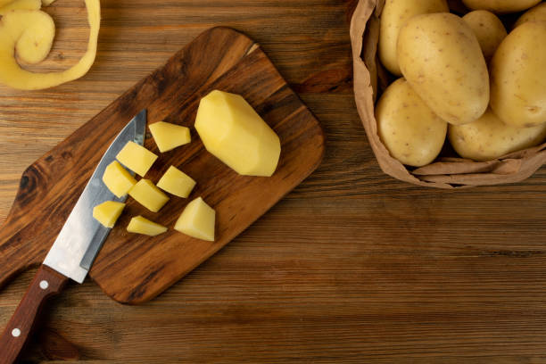 istock Raw Chopped Potato on Wooden Cutting Board Background 1283796788