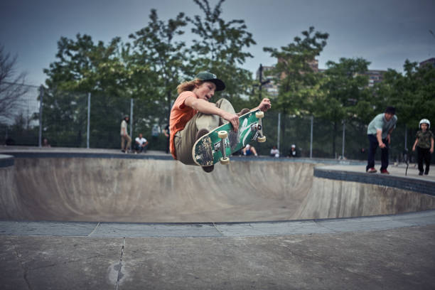 skateboarder agarrando tabla en el aire - skateboarding skateboard park extreme sports sport fotografías e imágenes de stock