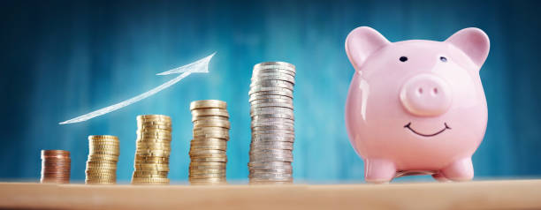 istock piggy bank with stacked coins on blue background 1283801257