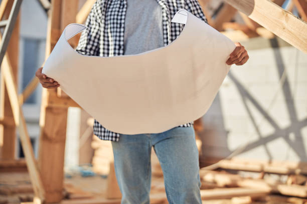 istock Professional engineer holding a paper with a building plan 1283804830