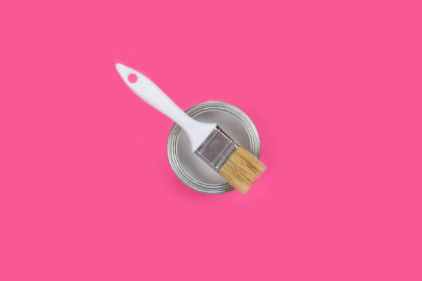 istock Open can with white paint and brush on pink background, 1283806381