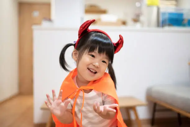 Asian child wearing Halloween costume in room
