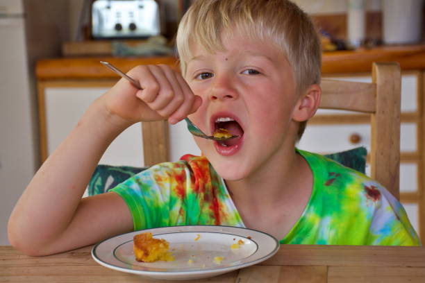istock Child in Tie Dye T-shirt Eating Cake 1283809152