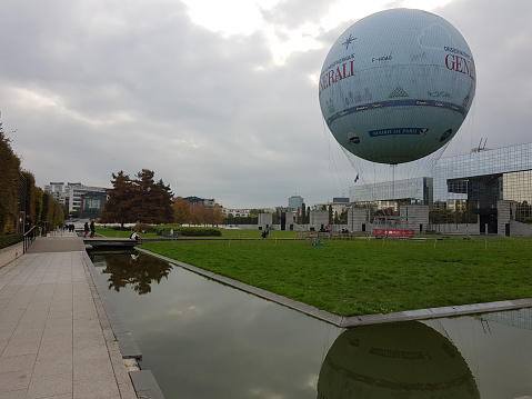 Paris, France - November 02, 2017:  The Ballon Generali is a tethered helium balloon, used as tourist attraction and as an air quality awareness tool. Installed in Paris, France. you can get a unique bird's eye view of Paris on board the world's biggest air-balloon, from an altitude of 150 meters