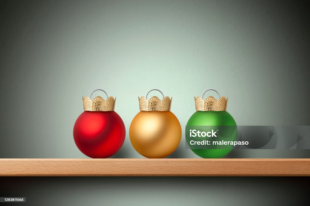Three wise men. Three Christmas balls on the sheft. Three colored Christmas balls with the top upside down similar to a royal crown on shelf. Three Wise Men Stock Photo