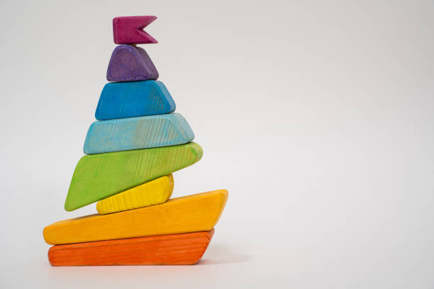 jouet pour enfants - une pyramide en forme de bateau à partir de plaques plates en bois multicolores. jouet pour développer la coordination des mains et la motricité. - nautical vessel isolated toy boat wood photos et images de collection