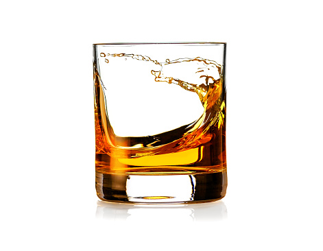 Glass of scotch Whiskey with splash isolated on white background