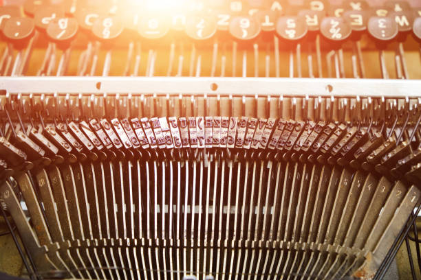 古いレトロタイプライターで英語のアルファベットを使ったタイプセッティングストライカーのメカニズム。太陽のまぶしさ。 - typewriter hammer retro revival typebar ストックフォトと画像