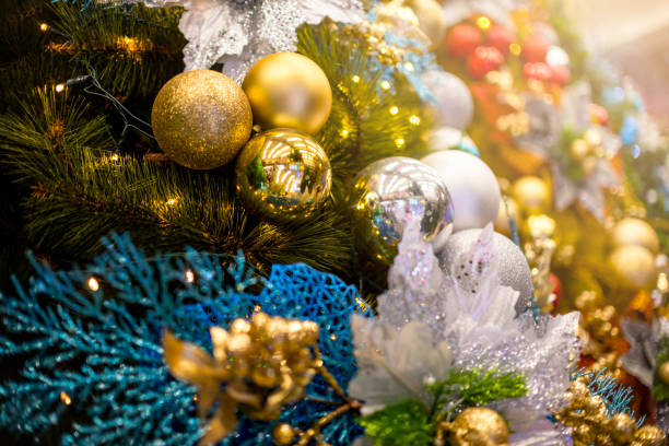 Closeup of a Christmas Tree lined with gold, silver and blue balls and ornaments, and warm led lights. Displayed at a local shop or department store for sale. Closeup of a Christmas Tree lined with gold, silver and blue balls and ornaments, and warm led lights. Displayed at a local shop or department store for sale. divisoria market stock pictures, royalty-free photos & images