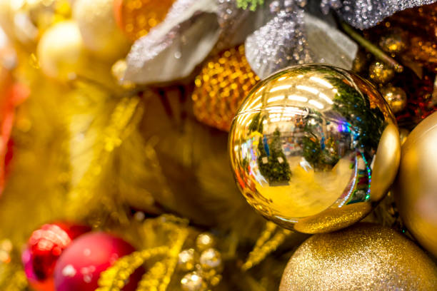 A golden vinyl Christmas tree decorated with gold, and red ornaments and balls, and orange garland. Displayed at a local shop or department store for sale. A golden vinyl Christmas tree decorated with gold, and red ornaments and balls, and orange garland. Displayed at a local shop or department store for sale. divisoria market stock pictures, royalty-free photos & images