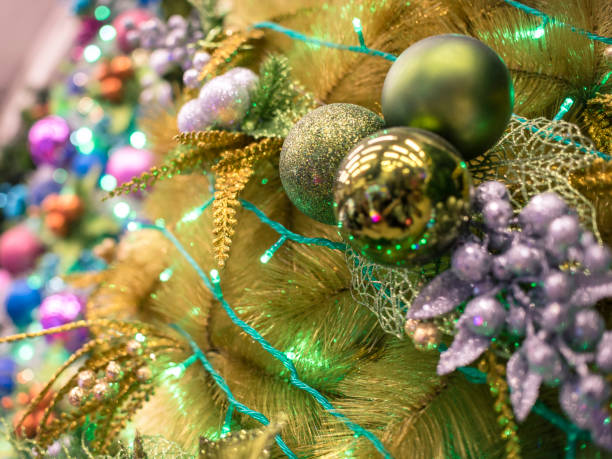 Closeup of a yellow vinyl Christmas Tree lined with Silver and Gold Christmas ornaments, and green LED lights. Displayed at a local store for sale. Closeup of a yellow vinyl Christmas Tree lined with Silver and Gold Christmas ornaments, and green LED lights. Displayed at a local store for sale. divisoria market stock pictures, royalty-free photos & images