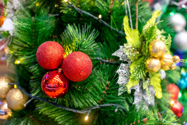 Closeup of a Christmas Tree lined with Red and Gold Christmas balls and ornaments, and warm led lights. Displayed at a local shop or department store for sale. Closeup of a Christmas Tree lined with Red and Gold Christmas balls and ornaments, and warm led lights. Displayed at a local shop or department store for sale. divisoria market stock pictures, royalty-free photos & images