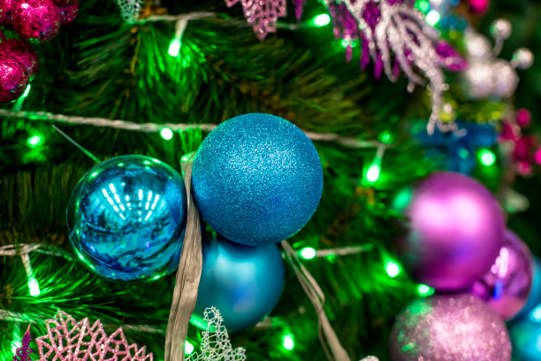 Closeup of a Christmas Tree lined with Blue and Purple Christmas balls, and green led lights. Displayed at a local store for sale. Closeup of a Christmas Tree lined with Blue and Purple Christmas balls, and green led lights. Displayed at a local store for sale. divisoria market stock pictures, royalty-free photos & images