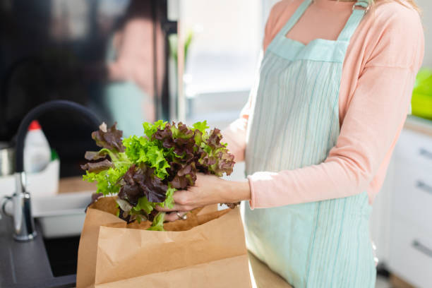 istock Taking lollo rosso lettuce from paper bag on the kitchen counter 1283819300