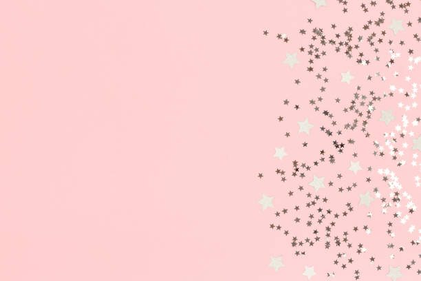 istock Silver stars confetti on a pink pastel background. 1283820837