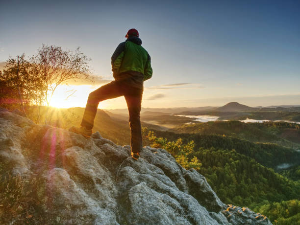 istock Man Walking On The Edge. Climber Enjoying Beautiful Nature View At Sunset After Challenging Climb 1283821239