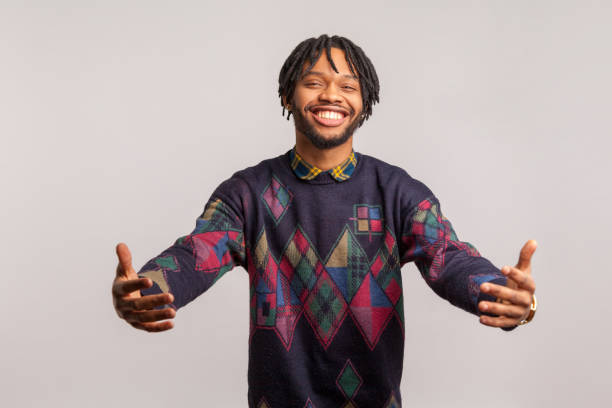 istock Friendly cheerful african guy with dreadlocks in casual style sweatshirt going to hug with toothy smile on face, happy to see, hospitality 1283823063