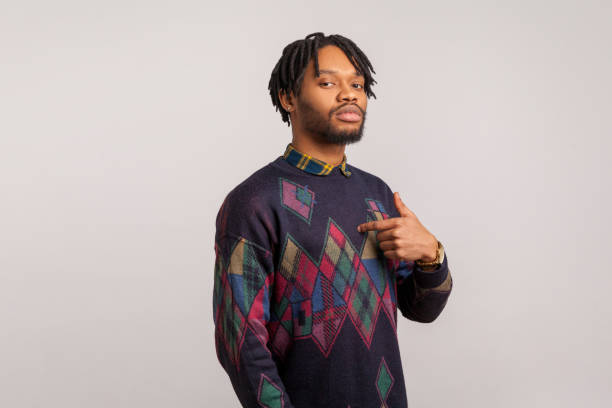 Selfish proud african man in stylish sweatshirt with dreadlocks egoistically pointing finger on himself, boasting and admiring his merits