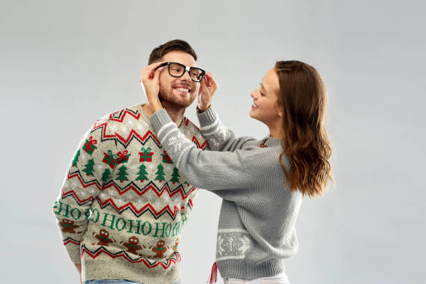 happy couple at christmas ugly sweater party christmas, people and holidays concept - portrait of happy couple at ugly sweater party christmas ugliness sweater nerd stock pictures, royalty-free photos & images