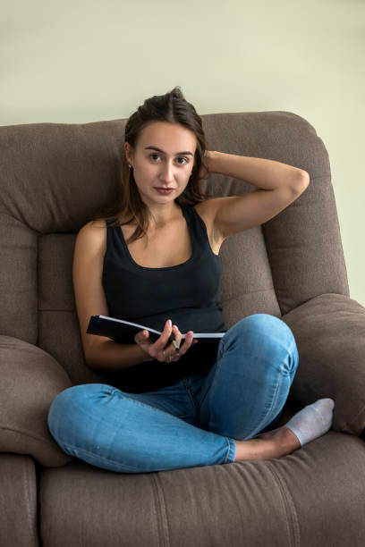 istock woman sitting in comfy sofa reading diary book enjoy free time 1283825475